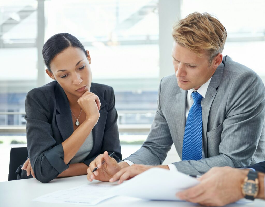 Reviewing their assets and liabilities. Shot of businesspeople looking over documents.