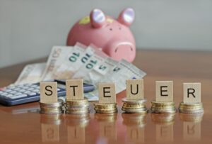 Letters spelling "Steuer" (German for taxes) on stacks of coins