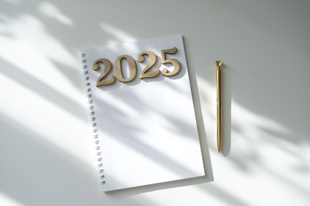 Blank notepad mockup and golden numbers 2025. Wish list and goals for 2025