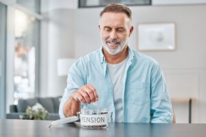 Shot of a mature man sitting alone at home and putting money aside for his pension